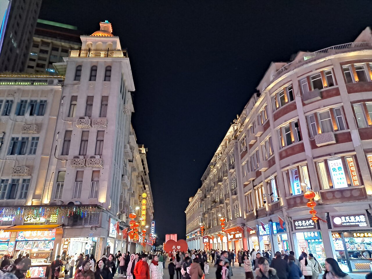Crowds along the lit historic arcade buildings of Zhongshan Road, Xiamen