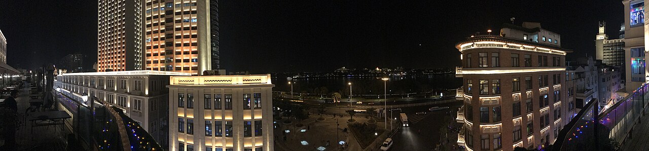Illuminated shopfronts and buildings on Zhongshan Road after dark